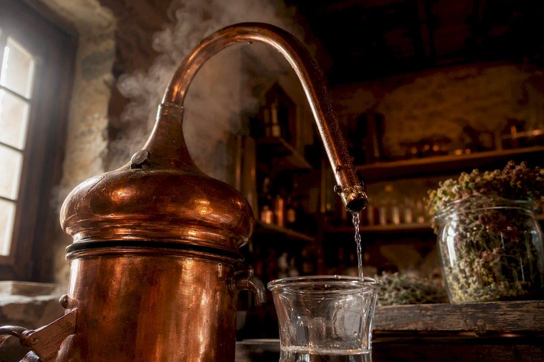 Alambic en cuivre versant le distillat dans la distillerie