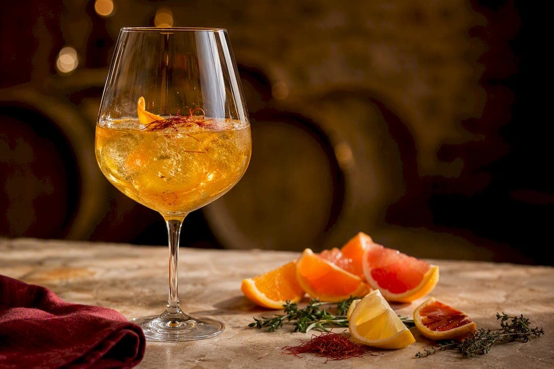 Cocktail au safran doré, accompagné d'agrumes