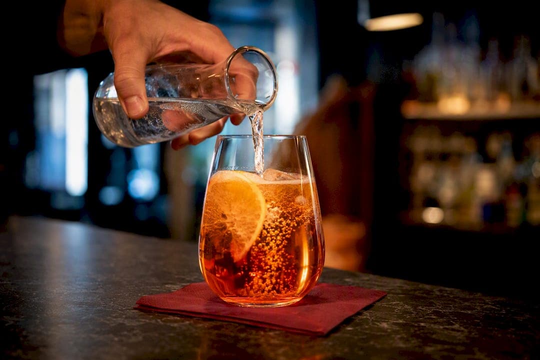Eau gazeuse versée dans un Spritz
