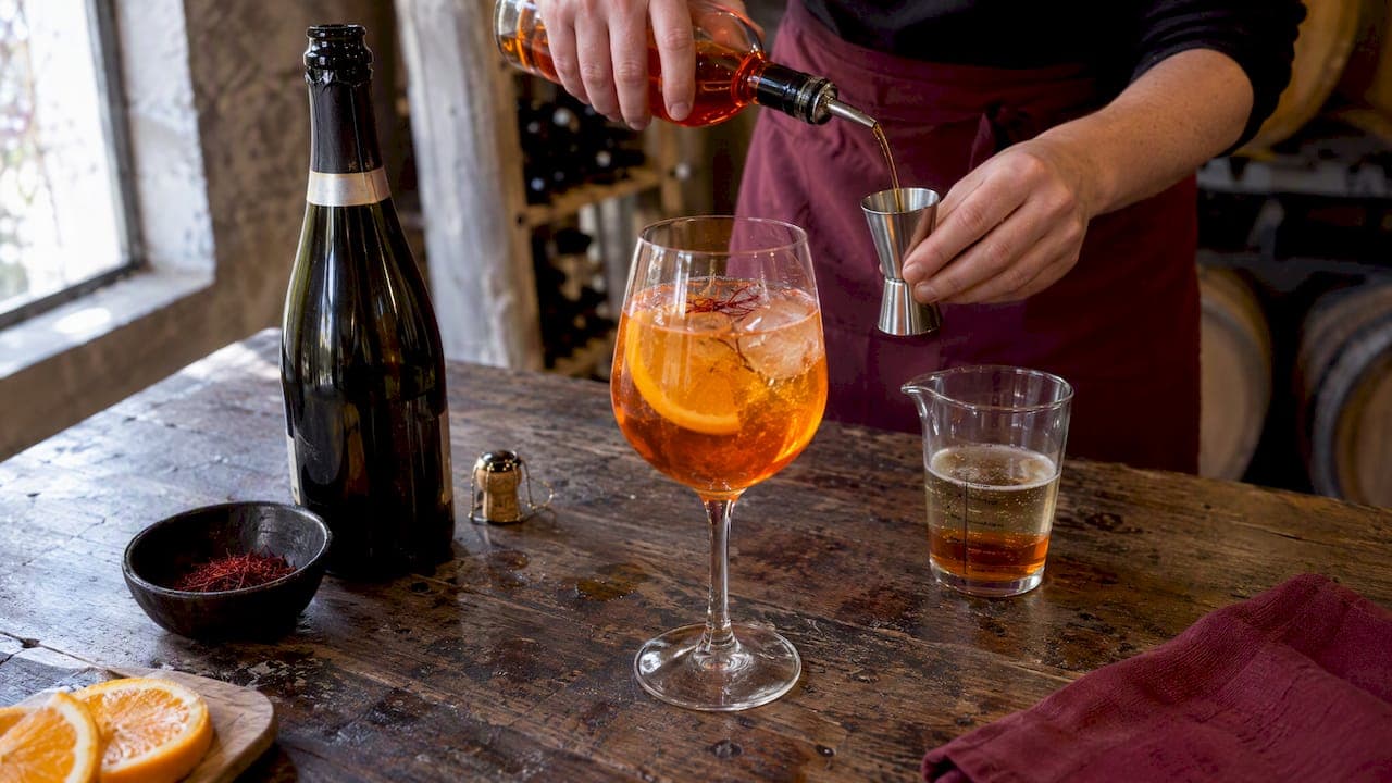 Spritz au safran servi avec un verre doseur