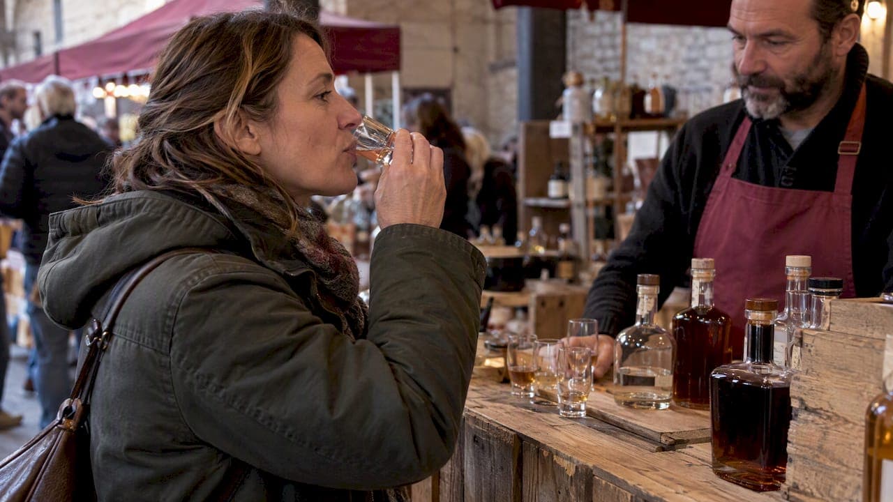 Une visiteuse savourant un spiritueux artisanal à Chimay