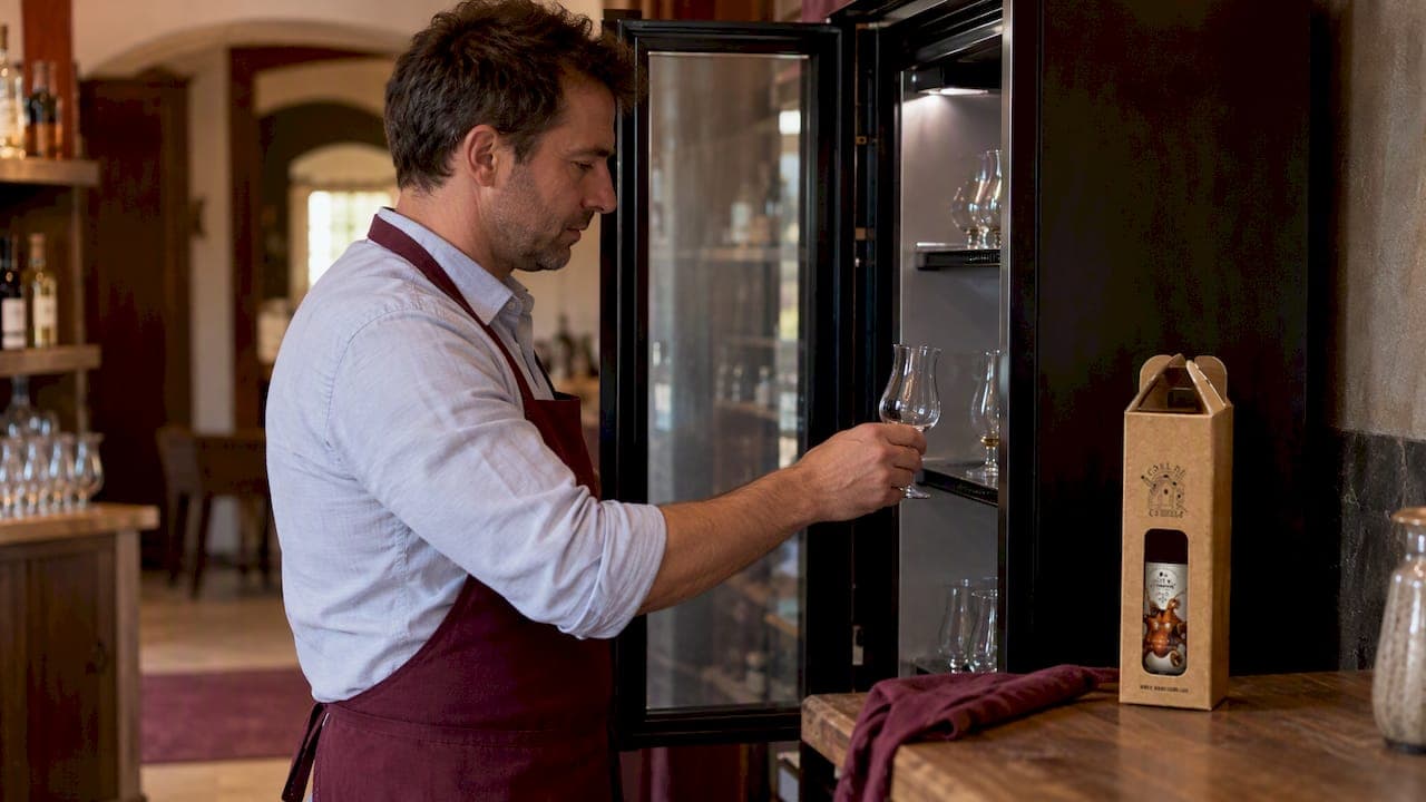 Un verre tulipe de rhum à côté du frigo